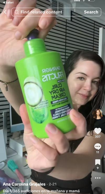 Ana holding Garnier Fructis Curl Air Dry Cream green bottle