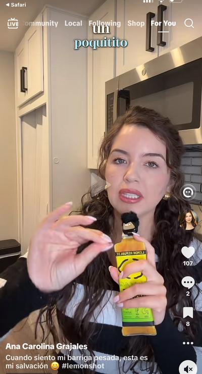 Ana holding Lemon Republic shot bottle in kitchen