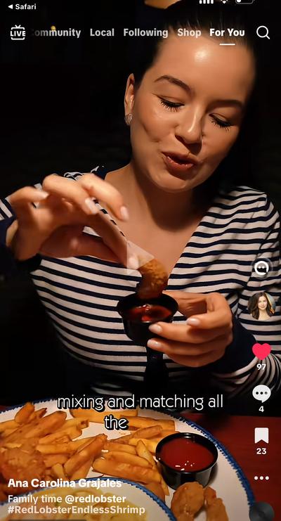 Ana in striped shirt dipping shrimp at Red Lobster